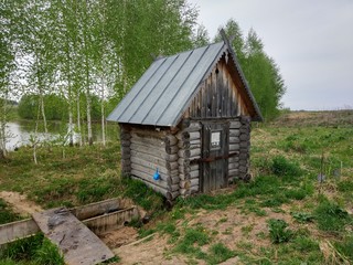 old small wooden house on a background of birches
