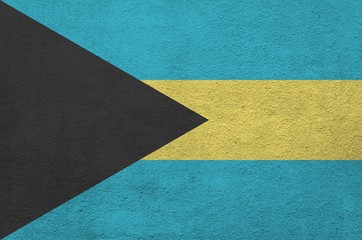 Bahamas flag depicted in bright paint colors on old relief plastering wall. Textured banner on...