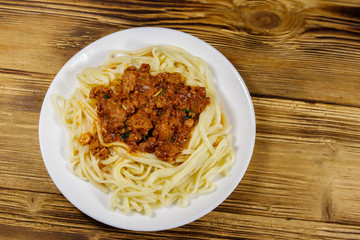 Pasta with bolognese sauce on wooden table