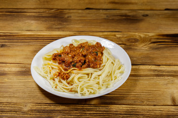 Pasta with bolognese sauce on wooden table