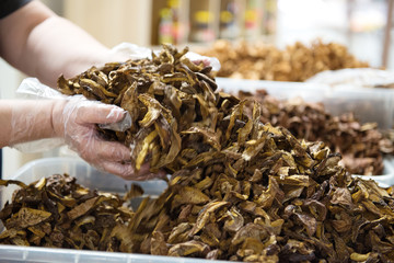Blended champignons in the hands of a saleswoman in a store.