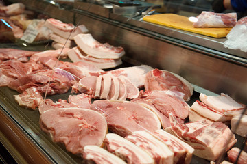 Sliced ​​raw meat behind the counter in the store.