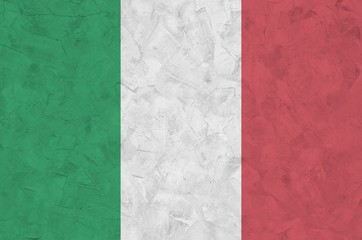 Italy flag depicted in bright paint colors on old relief plastering wall. Textured banner on rough...
