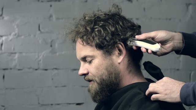 bearded mustachioed hipster cuts his hair