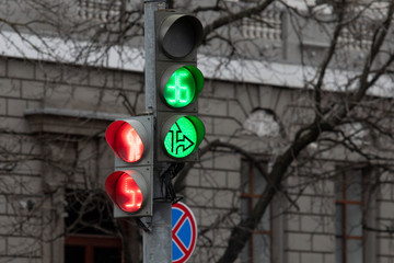 traffic light at the intersection with red and green lights and a road sign