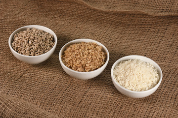 bowls with buckwheat, rice and sunflower seeds on jute