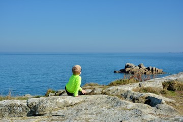 Young boy who is watching the sea in Brittany. France