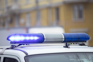 brightly glowing blue flashing light with a police car siren