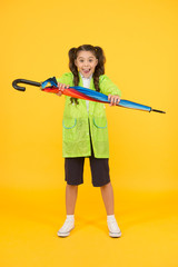 Waterproof concept. Match your raincoat with umbrella. Schoolgirl wear raincoat. Small schoolgirl...