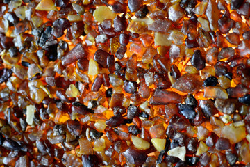 wall made of small amber pieces close-up, orange amber wall in beautiful light 
