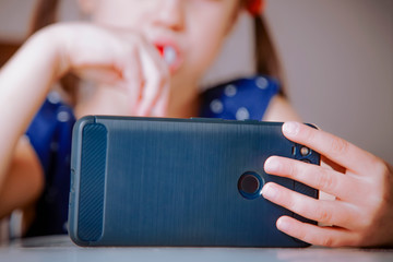 Game addiction concept. Top view of little child girl gaming on smart phones and mobile devices. Selective focus.