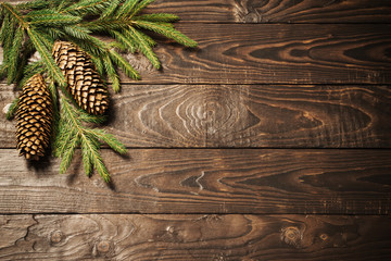 fir branches and cone on dark old wooden background
