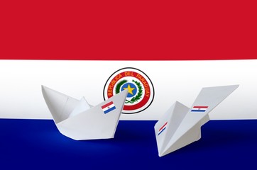 Paraguay flag depicted on paper origami airplane and boat. Handmade arts concept