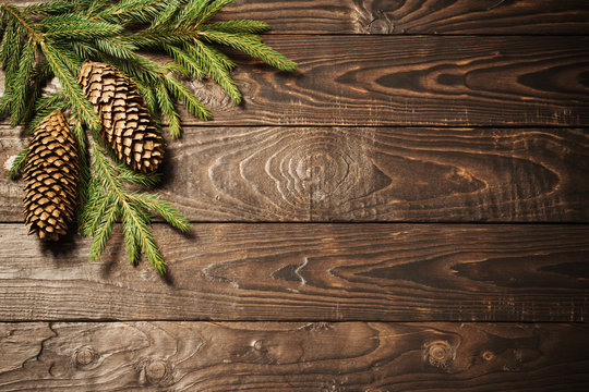 fir branches and cone on dark old wooden background
