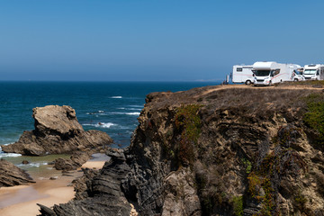 Campers parked on a cliff near the village of Porto Covo, in the Costa Vicentina Natural Park in Portugal; Concept for road trip in Portugal and summer vacations