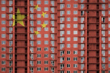 China flag depicted in paint colors on multi-storey residental building under construction....