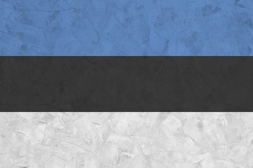Estonia flag depicted in bright paint colors on old relief plastering wall. Textured banner on...