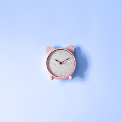 A clock in the shape of a cat on a classic blue background.