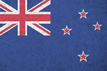 New Zealand flag depicted in bright paint colors on old relief plastering wall. Textured banner on...