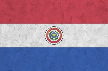 Paraguay flag depicted in bright paint colors on old relief plastering wall. Textured banner on...