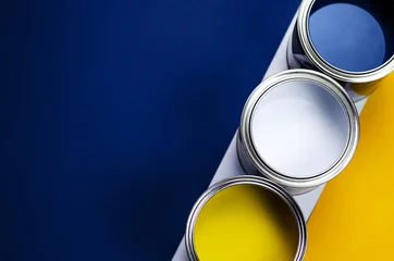 Fotobehang Cans of paint on a background of yellow and classic blue. © Maryna