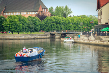 Obraz premium A pleasure boat sailing along the Pregolya river in the center of Kaliningrad