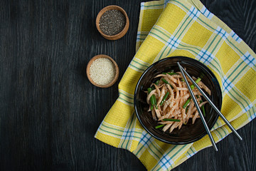 Salad with daikon radish, green onions, honey and red chili powder. Asian salad. Flat lay. Space for text. Dark background.