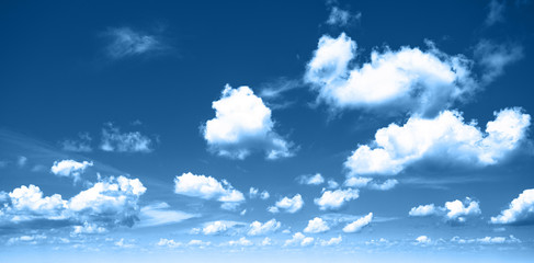 Beautiful classic blue colored sky background with sparse white clouds. Panorama. Color of the year 2020