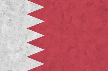 Bahrain flag depicted in bright paint colors on old relief plastering wall. Textured banner on...