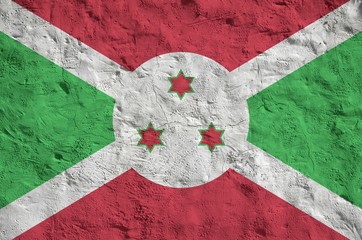 Burundi flag depicted in bright paint colors on old relief plastering wall. Textured banner on...