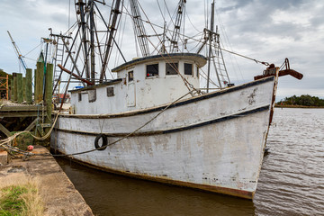 old white shrimp fishing boat at dock