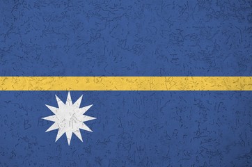 Nauru flag depicted in bright paint colors on old relief plastering wall. Textured banner on rough...