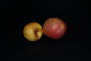 apples and pears on black background