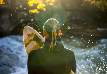 Isarsurfer - Surferin mit Brett, wartet auf Ritt, im Gegenlicht (Flares)