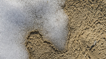 Obraz premium melting snow and ice on a sunny day by the river. Early spring.