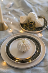 Christmas table setting with stoneware ceramic plates and origami decorations