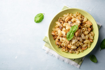 Pasta with chicken, mushrooms and parmesan cheese on concrete background. Top view, copy space.