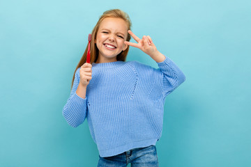 beautiful european girl holding a toothbrush in her hands on a light blue background