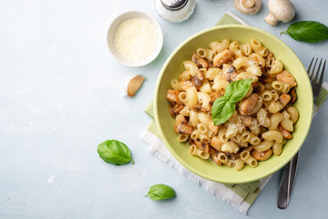 Pasta with chicken, mushrooms and parmesan cheese on concrete background. Top view, copy space.