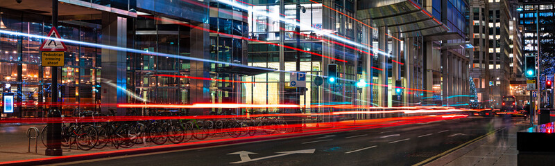 Busy city street at night with light streaks from vehicles panoramic