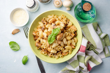 Pasta with chicken, mushrooms and parmesan cheese on concrete background. Top view.
