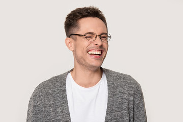 Happy young man laughing at funny joke squinting his eyes