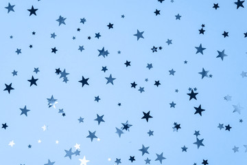 Delicate glitter stars background toned blue color. Creative and moody color of the picture.