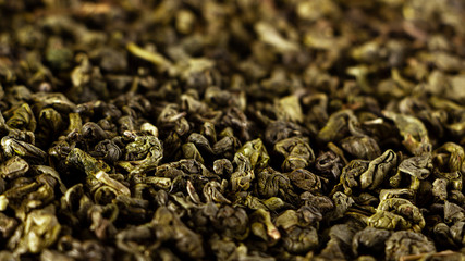 Green dry tea texture closeup, selective focus