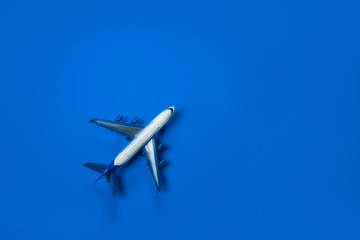 Naklejka na ściany i meble Blue color of the Year 2020 inscription. Model airplane, plane on blue background. Directly above. Travel, vacation, summer concept. Flat lay, top view, cope space.
