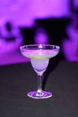 classic Margarita in a wine glass on a table in neon light