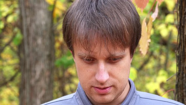 Portrait of young courageous man in autumn forest
