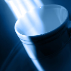 White single cup with asymmetry of light. Trend color of 2020 - Classic Blue