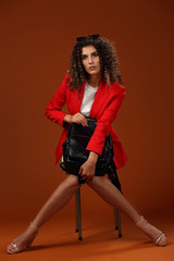 Beautiful girl in white dress and red jacket with black bag