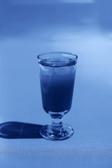 Coctail with ice on the blue background.